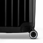 Détail de la roue et du logo GYL sur le bas de la valise trunk noir en polycarbonate brillant. #couleur_noir