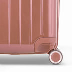 Détail de la roue et du logo GYL sur le bas de la valise trunk rose gold en polycarbonate brillant. #couleur_rose gold