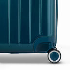 Détail de la roue et du logo GYL sur le bas de la valise trunk sapin en polycarbonate brillant. #couleur_sapin
