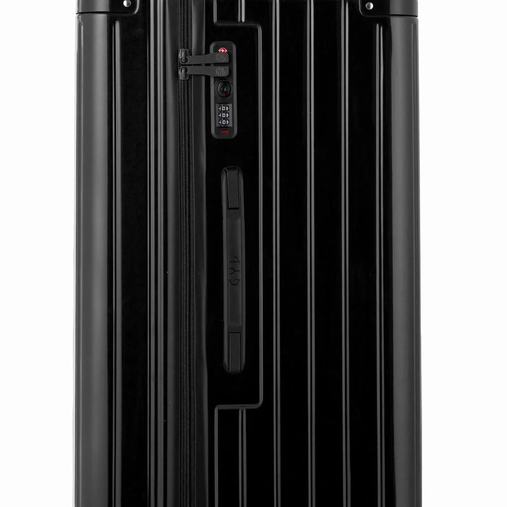 Détail de la serrure TSA et de la poignée latérale sur la valise trunk noir. #couleur_noir