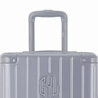 Zoom sur la poignée trolley et le logo GYL de la valise trunk argent. #couleur_argent