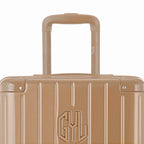 Zoom sur la poignée trolley et le logo GYL de la valise trunk champagne. #couleur_champagne