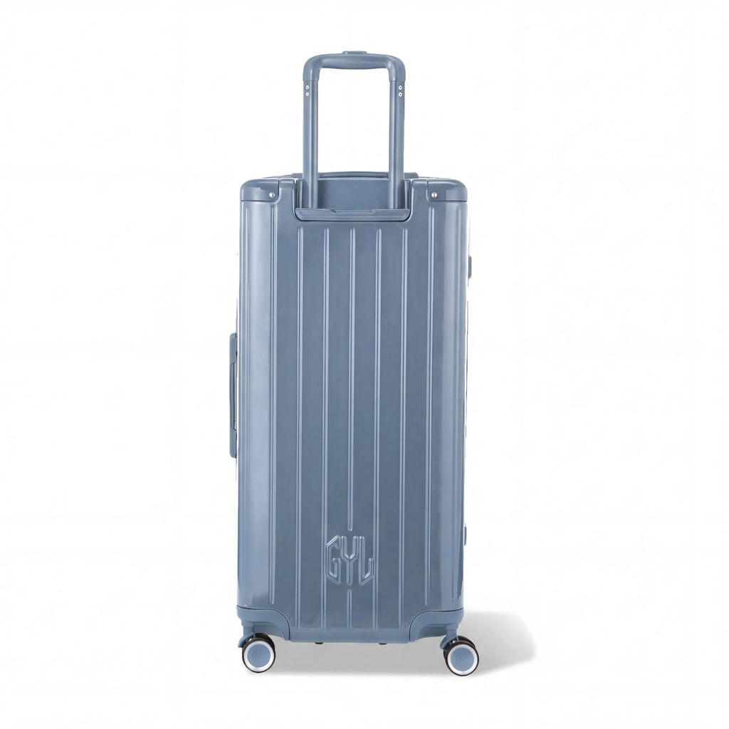 Dos de la valise trunk GYL XL bleu gris avec trolley télescopique sorti et logo embossé. #couleur_bleu grisé