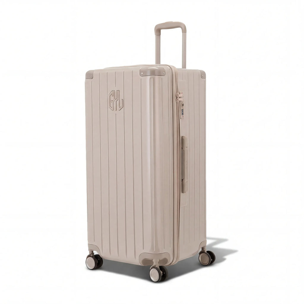 Valise trunk GYL taille XL en polycarbonate nude vue de trois quarts, avec trolley déployé et roues 360°. #couleur_nude