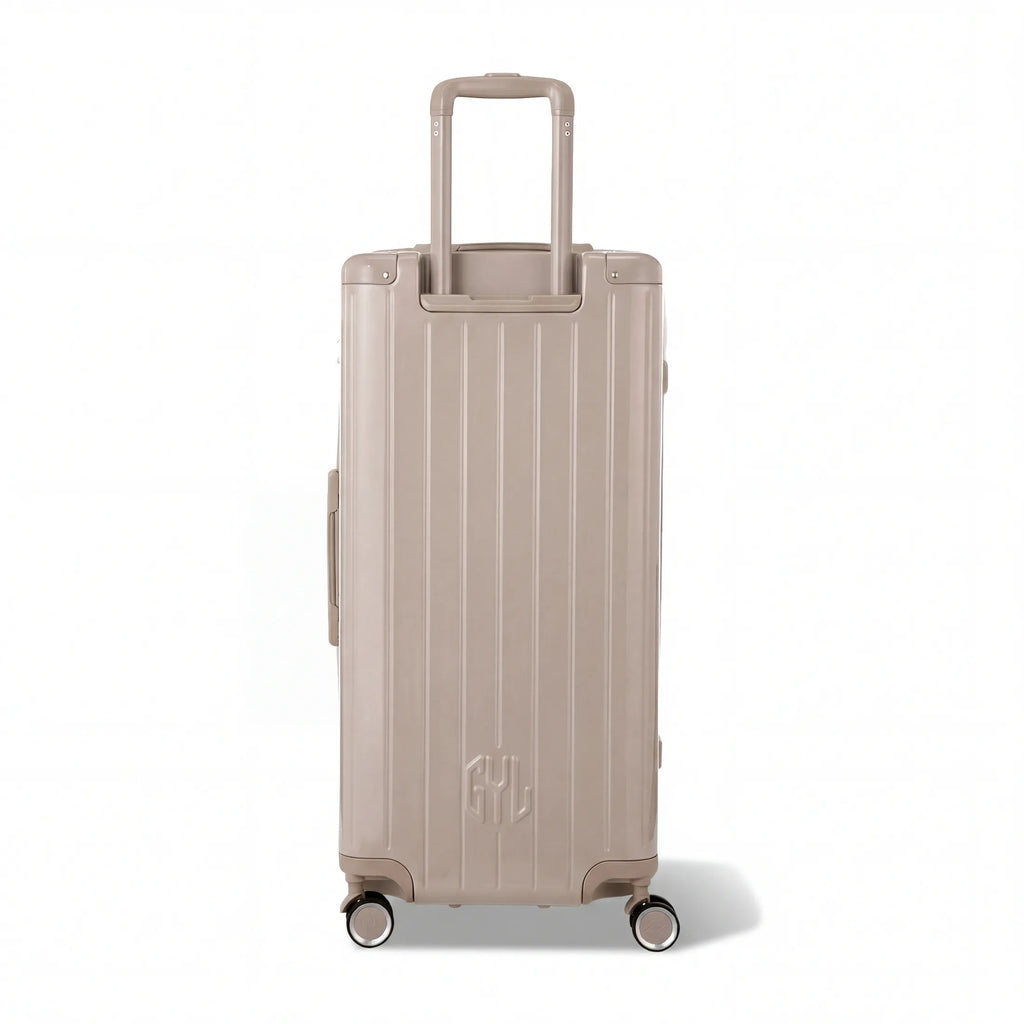 Dos de la valise trunk GYL XL nude avec trolley télescopique sorti et logo embossé. #couleur_nude