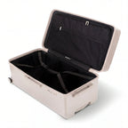 Intérieur de la valise trunk GYL XL nude ouvert, avec sangles croisées. #couleur_nude