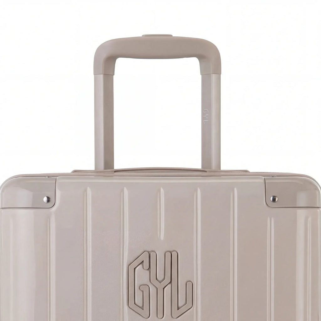 Zoom sur la poignée trolley et le logo GYL de la valise trunk nude. #couleur_nude