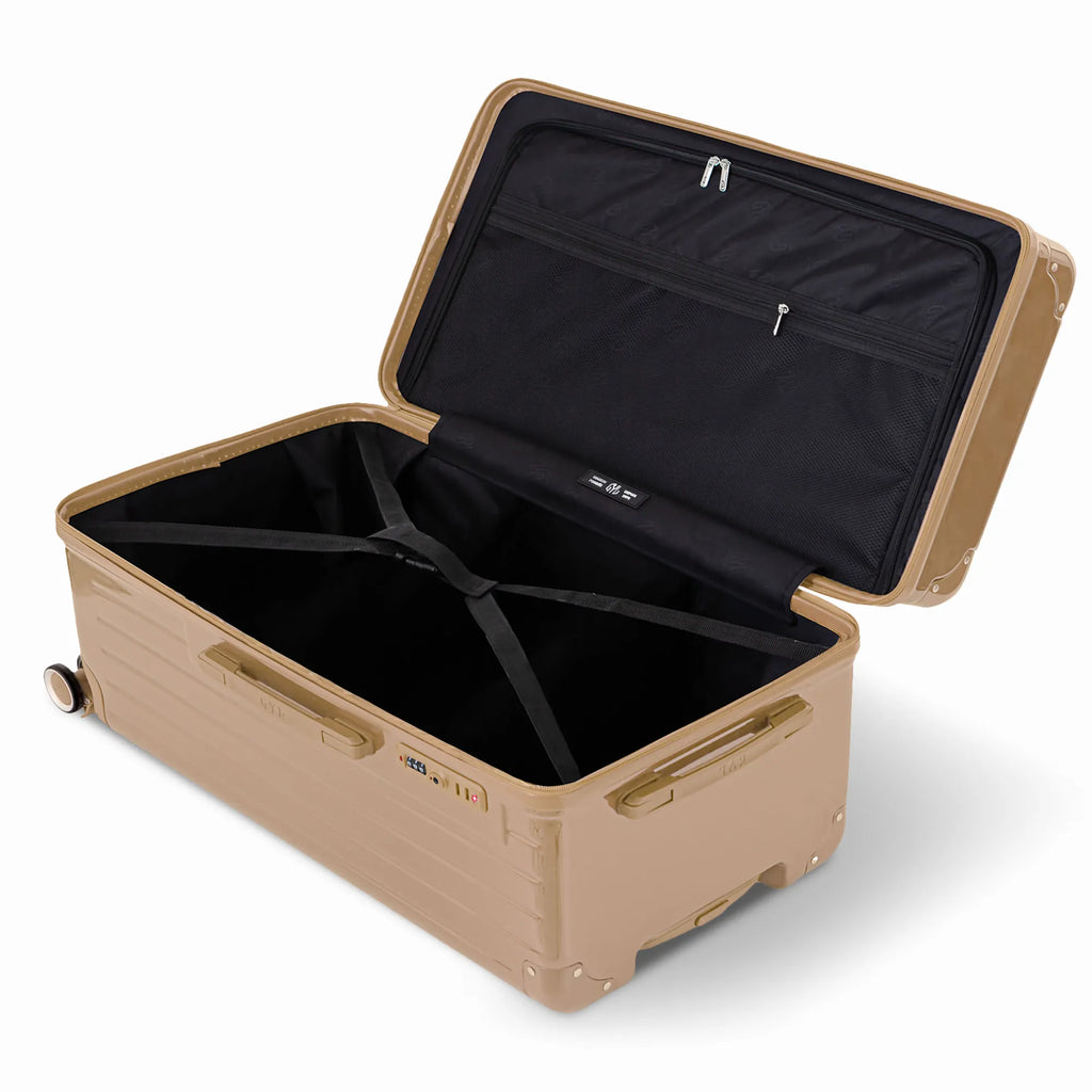 Intérieur de la valise trunk GYL XL champagne ouvert, avec sangles croisées et compartiments de rangement. #couleur_champagne