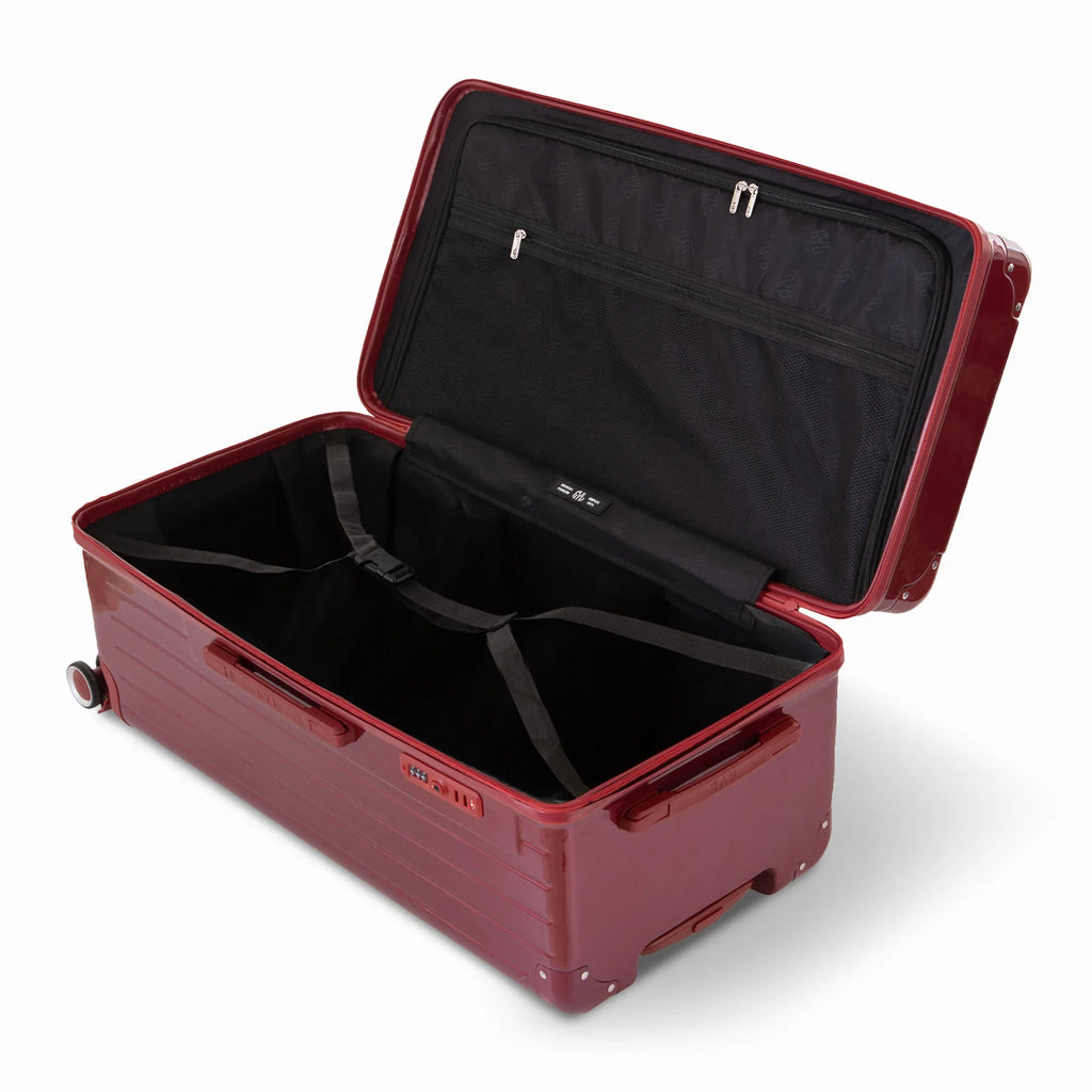 Intérieur de la valise trunk GYL XL rouge foncé ouvert, avec sangles croisées. #couleur_rouge foncé