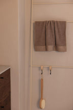 Handtuchleiter mit einem handtuch und einer Bürste, ideal für Badezimmeraccessoires.
