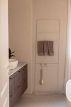 Handtuchleiter Estina im Badezimmer mit Handtüchern und Badutensilien, modernes Design.