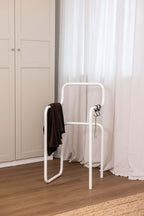 Minimalist Herrendiener JAMES mit braunem Tuch in einem modernen Schlafzimmer.