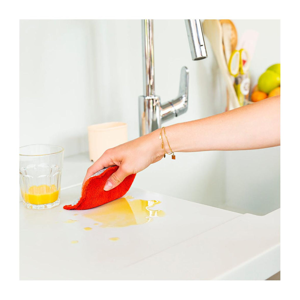 Eponge lavable rouge essuyant du jus d'orange 