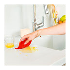 Eponge lavable rouge essuyant du jus d'orange 