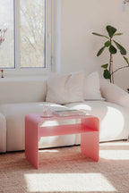 Beistelltisch COSMO in Pink neben einem weißen Sofa mit Kissen, ideal für stilvolles Wohnen.