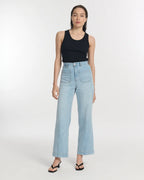 Jean femme en denim léger couleur bleu clair, coupe large et droite avec taille haute et poches plaquées à l’avant, offrant un style décontracté et confortable.