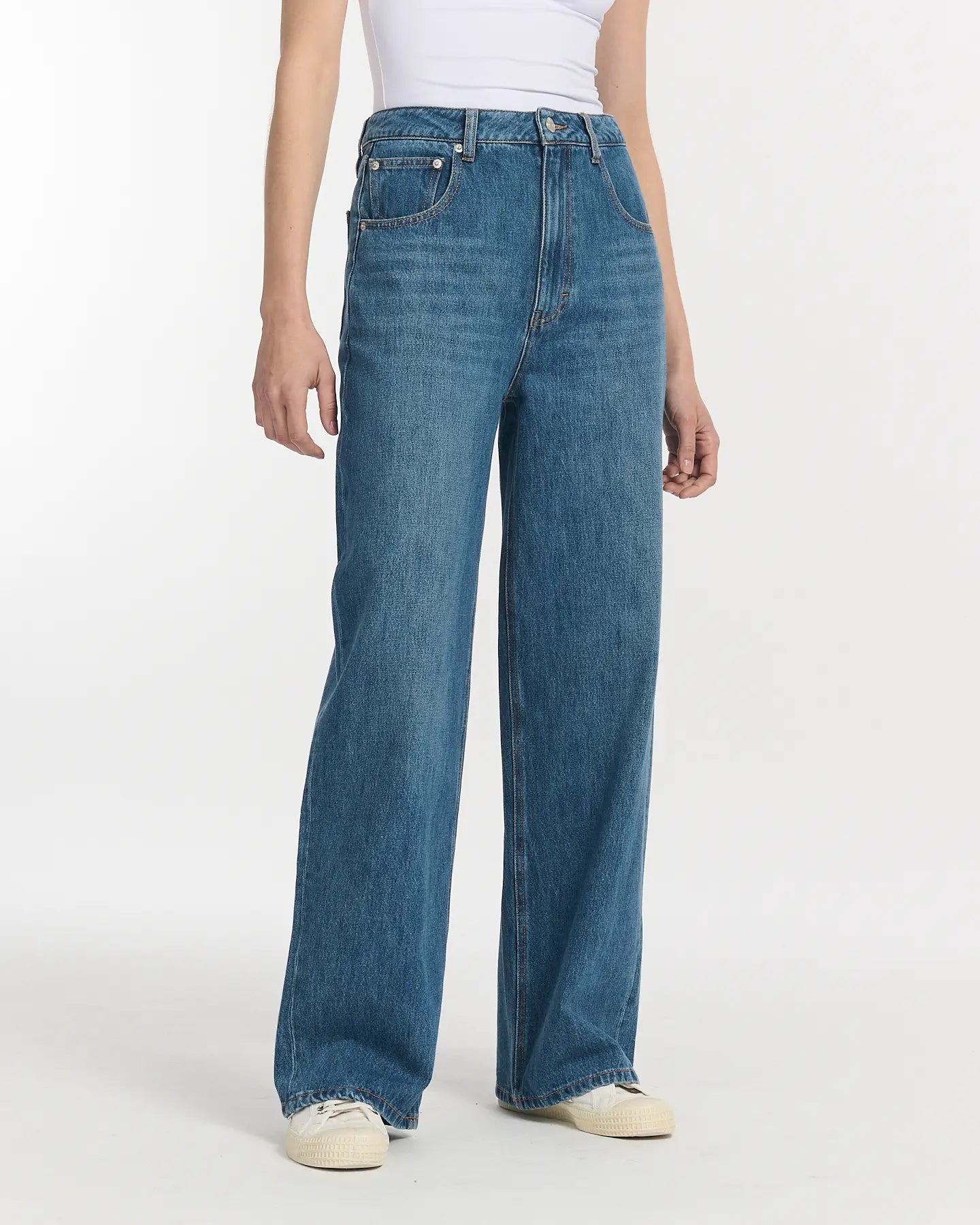 Jean en denim bleu moyen 100% coton avec coupe large et taille haute, offrant un confort décontracté et une silhouette fluide adaptée à toutes les morphologies femme.