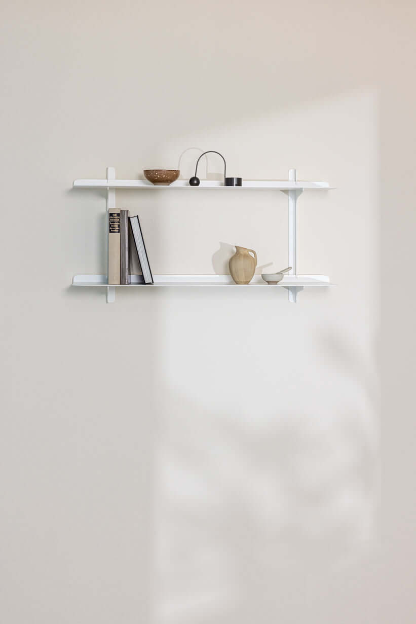 Wandregal LINARA mit Büchern und Dekorationselementen in modernem, minimalistischem Design.