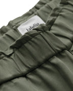 Détail d’un pantalon en tissu tencel kaki avec une taille élastiquée et une coupe confortable, idéal pour un jean femme alliant douceur et style décontracté.