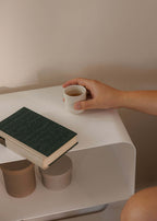 Stehender Nachttisch mit einem Buch und einer Tasse auf der Oberfläche, minimalistische Eleganz im modernen Stil.