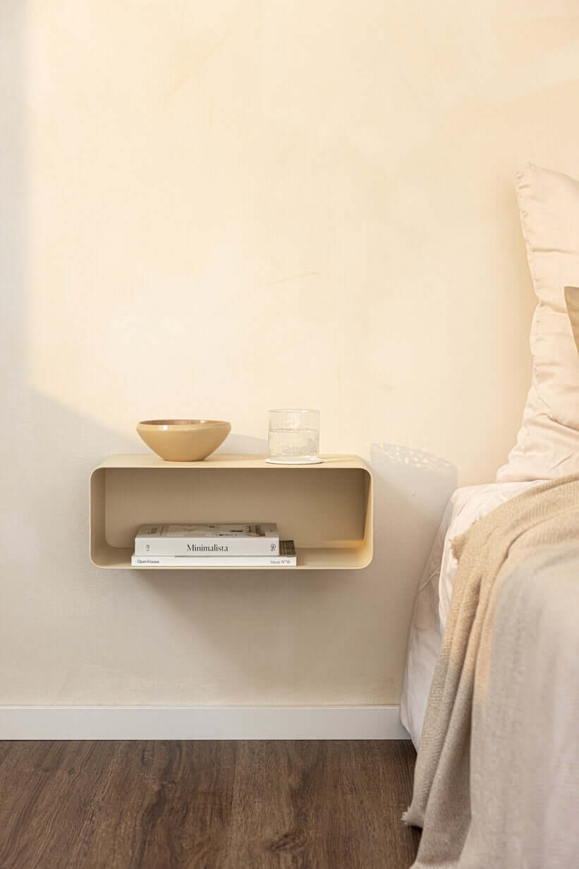 Hängender Nachttisch NELIO in minimalistischer Formensprache über einem Bett mit Deko-Objekten.
