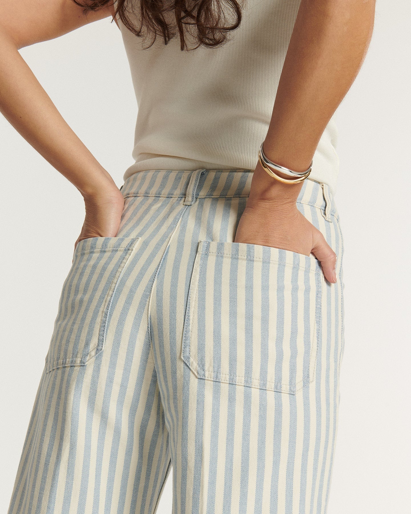 Jean femme en denim rayé bleu clair et écru, coupe droite et taille haute, tissu en coton confortable adapté à toutes les morphologies.