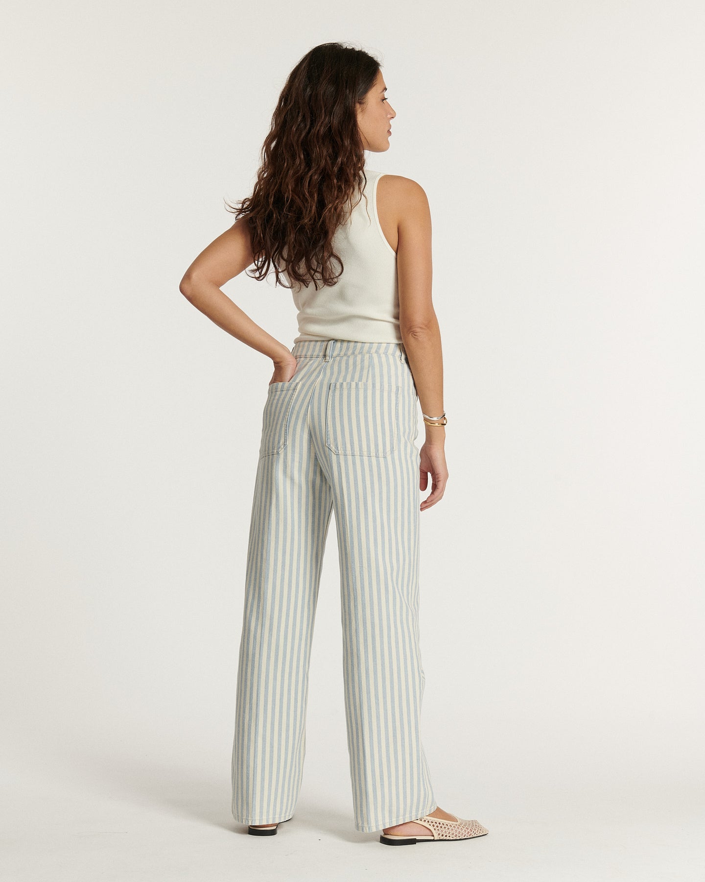 Jean pour femme en coton à rayures bleu clair et blanc, coupe droite et taille haute, offrant un style estival et décontracté adaptable à toutes les morphologies.