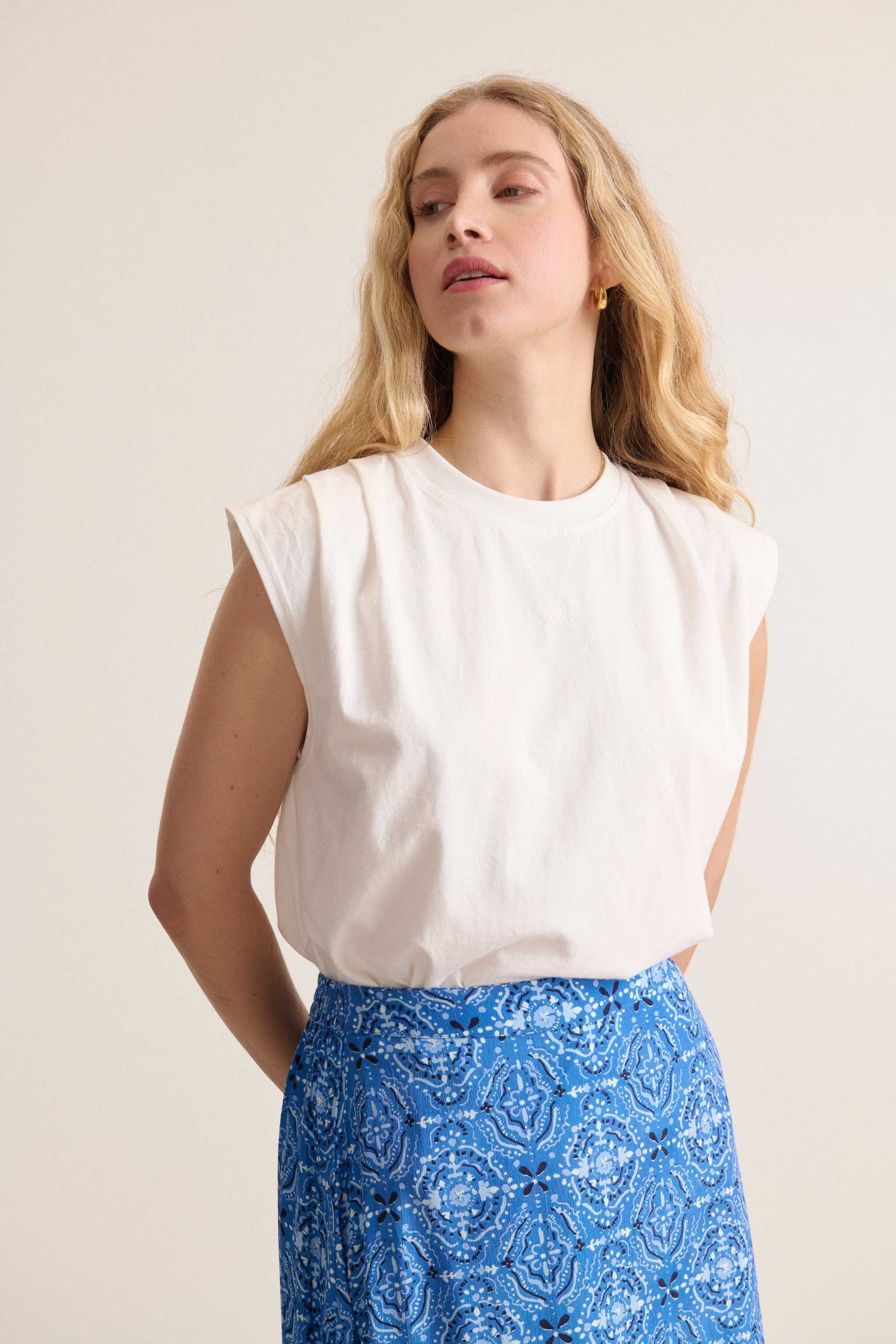 Tee-shirt blanc sans manches, col rond, plis aux épaules parfait pour la saison estivale