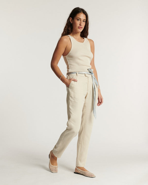 Jean femme en toile légère couleur écume, coupe droite ajustée avec ceinture fine nouée, offrant un confort estival élégant et facile à porter.