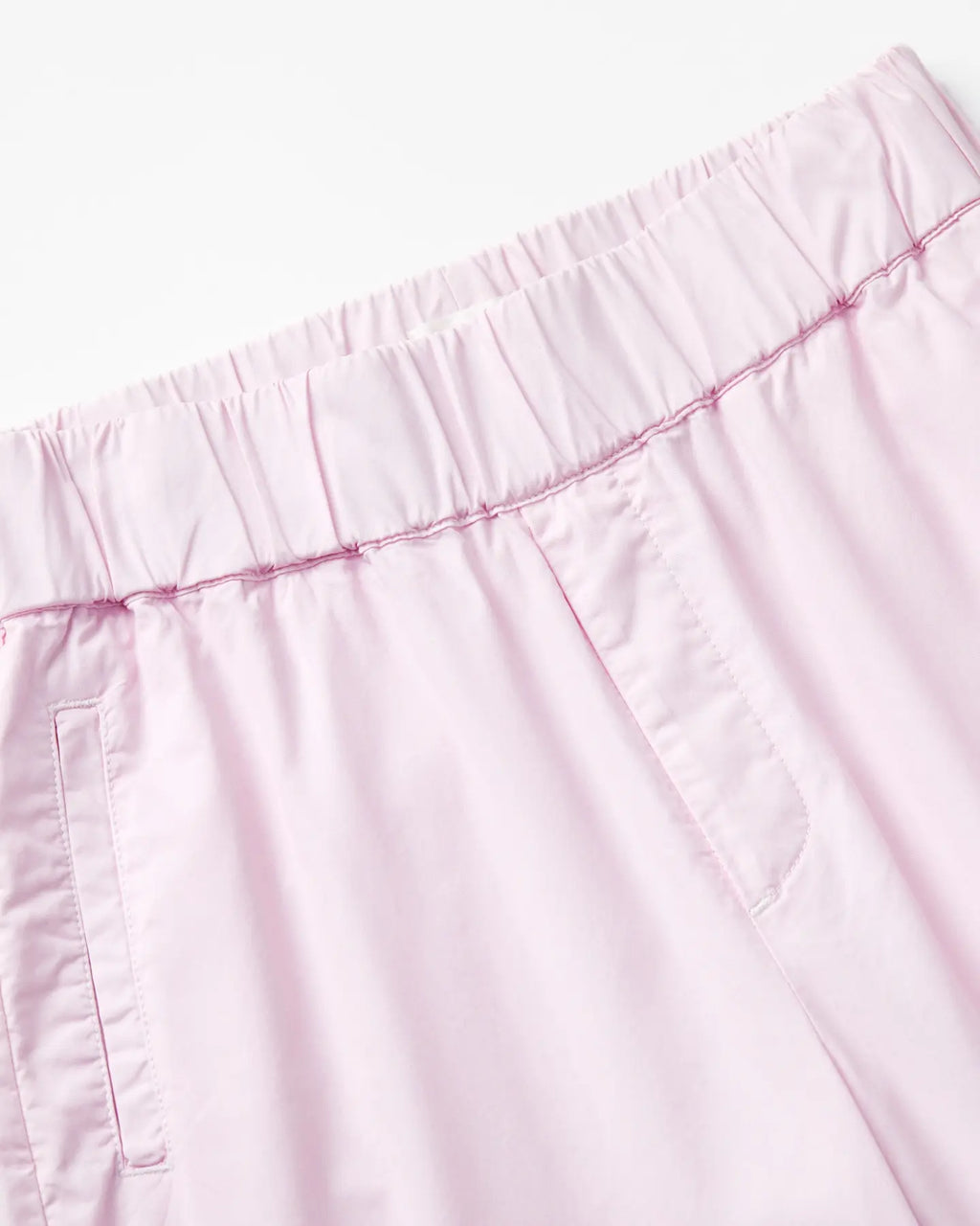 Pantalon en popeline légère couleur rose pâle avec taille élastique, coupe droite et détails couture apparents pour un confort et une allure décontractée femme.