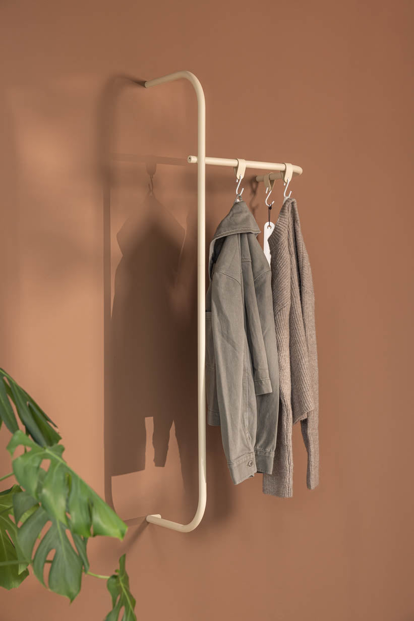 Moderne Garderobe TAMINA mit minimalistischen Metallstangen und Kleidung in einem stilvollen Raum.