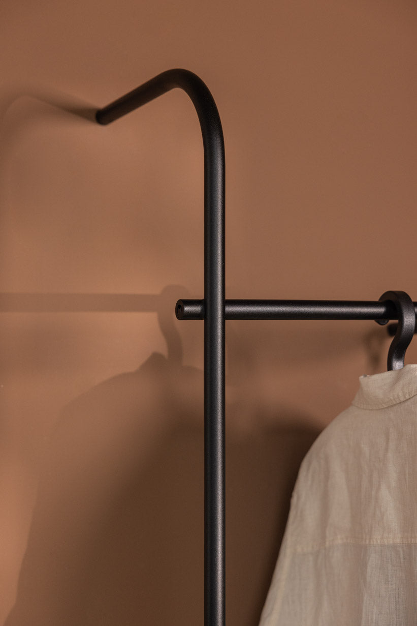 Detailansicht der GARDEROBE TAMINA mit minimalistischem Design und runder Metallstange.