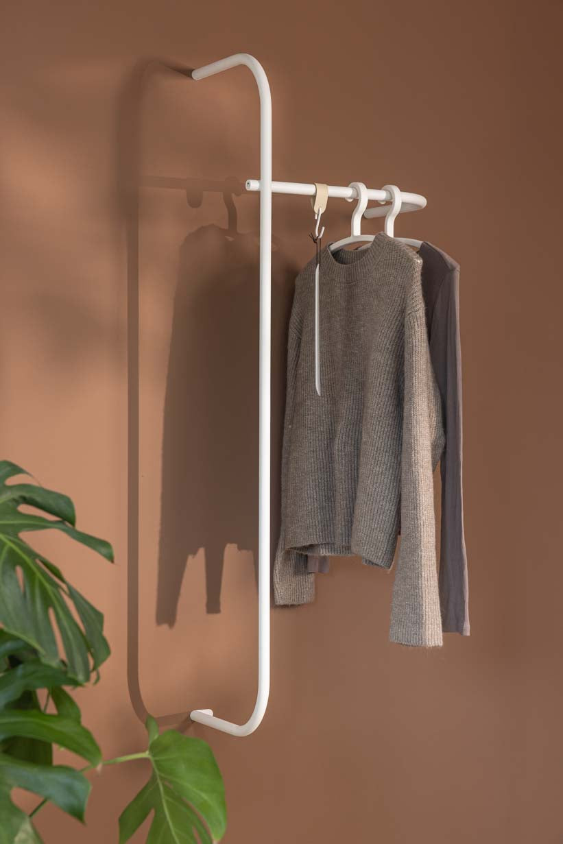 Moderne Garderobe TAMINA mit minimalistischen Metallstangen und aufgehängten Kleidungsstücken.