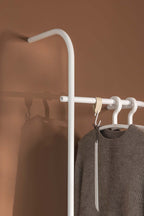 Garderobe TAMINA mit minimalistischen Metallstangen und einem grauen Pullover, ideal für modernen Stil.