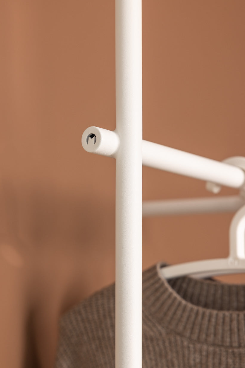 Detailansicht der Garderobe TAMINA mit runder Metallstange und Kleiderbügel.