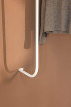 Detailansicht der Garderobe TAMINA mit grauem Pullover an einer weißen Metallstange.