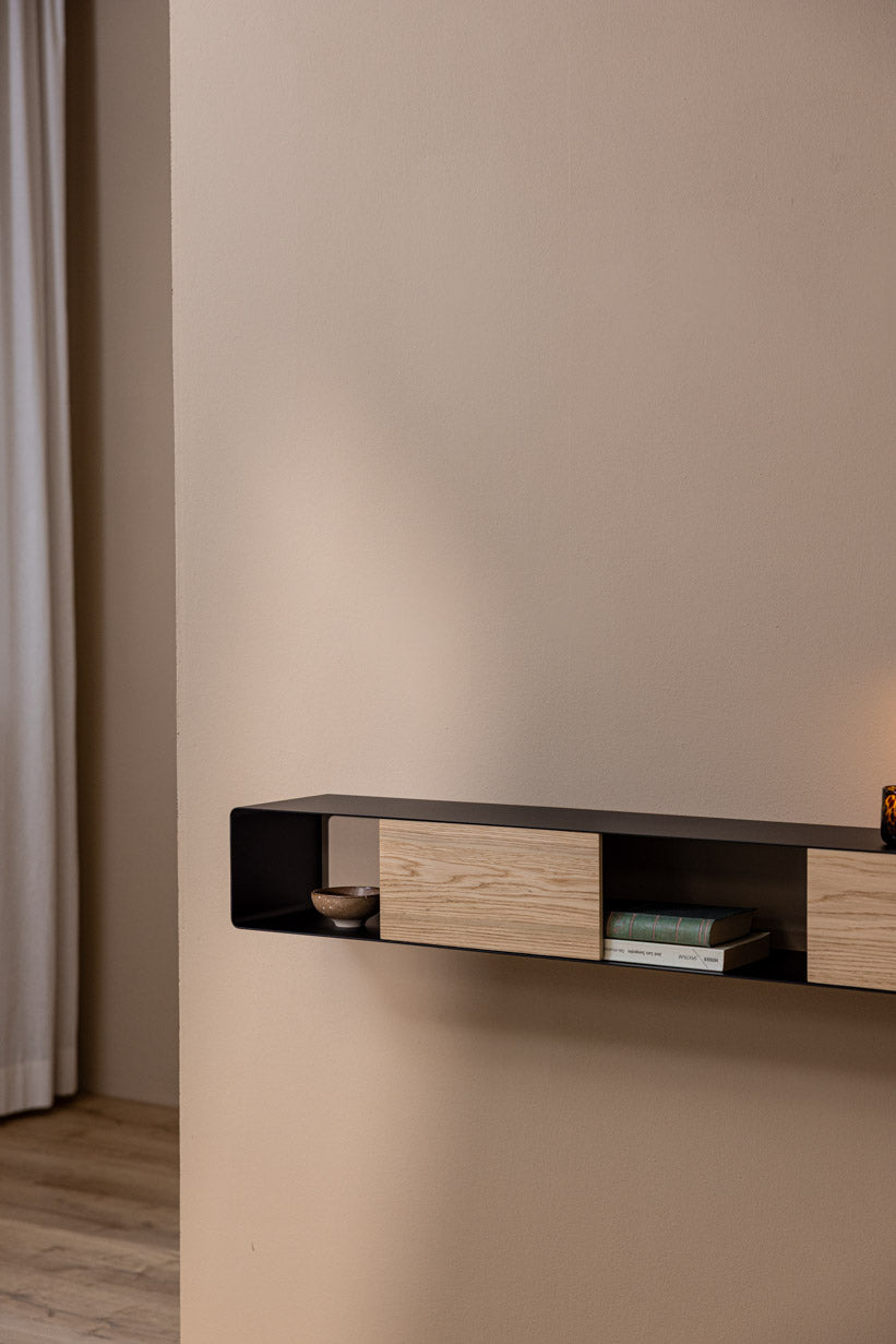 Hängekonsole SION an einer Wand mit Holzregal und Dekoration.