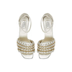 Elegant silver high-heeled sandals with unique braided design and ankle strap, perfect for formal occasions.