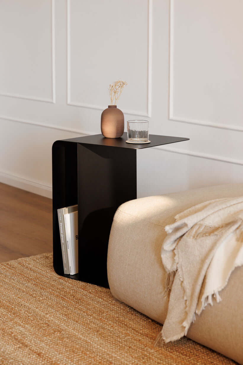 Beistelltisch COSMO aus pulverbeschichtetem Metall in modernem Design neben Sofa mit Deko