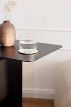 Beistelltisch COSMO mit einem Glas Wasser und einer Vase auf der Tischoberfläche in modernem minimalistischen Design.