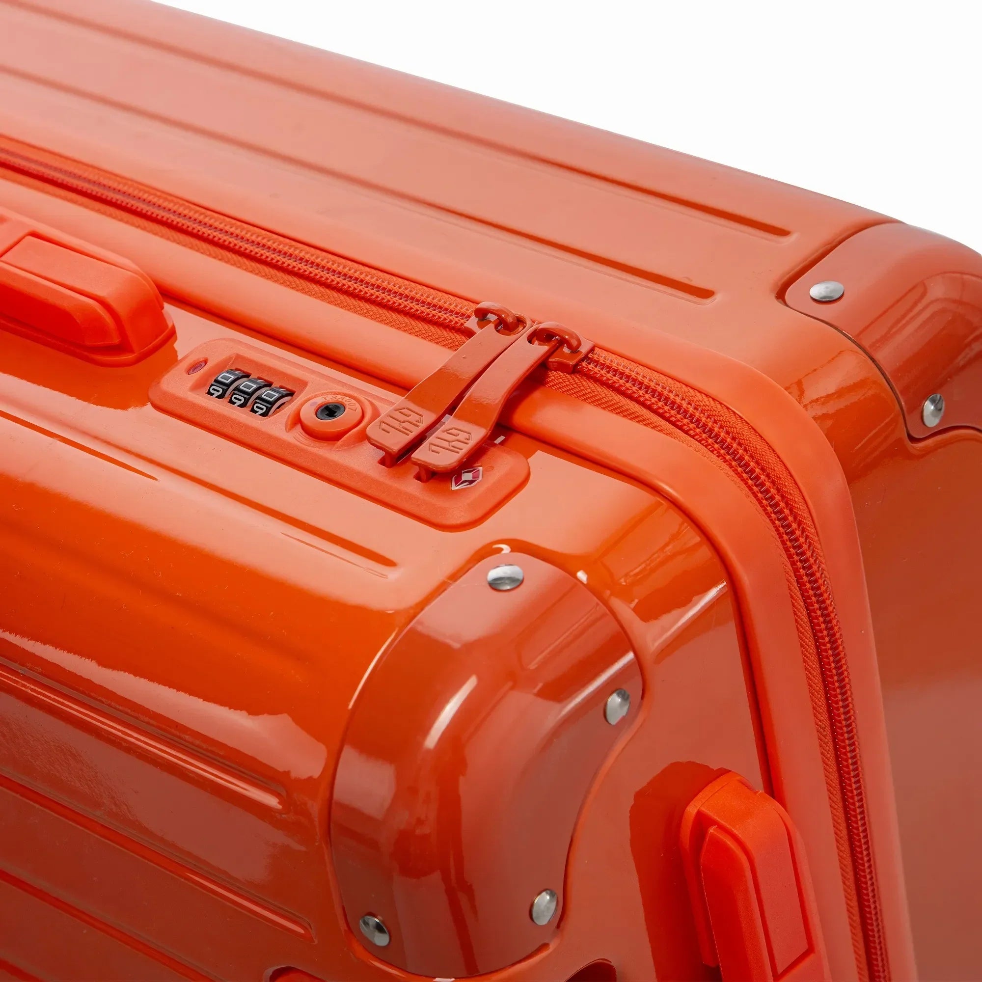 Fermeture à combinaison TSA et double curseur zippé GYL sur la valise rigide orange Intemporelle. #couleur_orange
