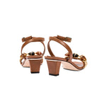 Delphine Camello mid-heel ankle cross sandals featuring a chic brown design with decorative details and secure buckle.