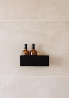 Duschablage SHEA mit zwei Flaschen auf einem stilvollen schwarzen Regal in der Dusche