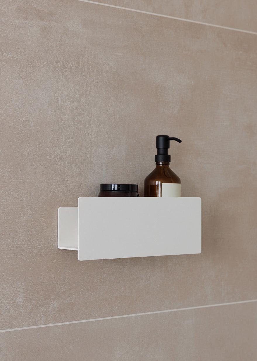 Duschablage SHEA an einer Wand mit Pflegeprodukten in der Dusche, schlichtes Design für optimale Aufbewahrung.