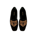 Fiocco black velvet flat moccasin with antique gold embroidered bow, highlighting comfort and chic autumn style.