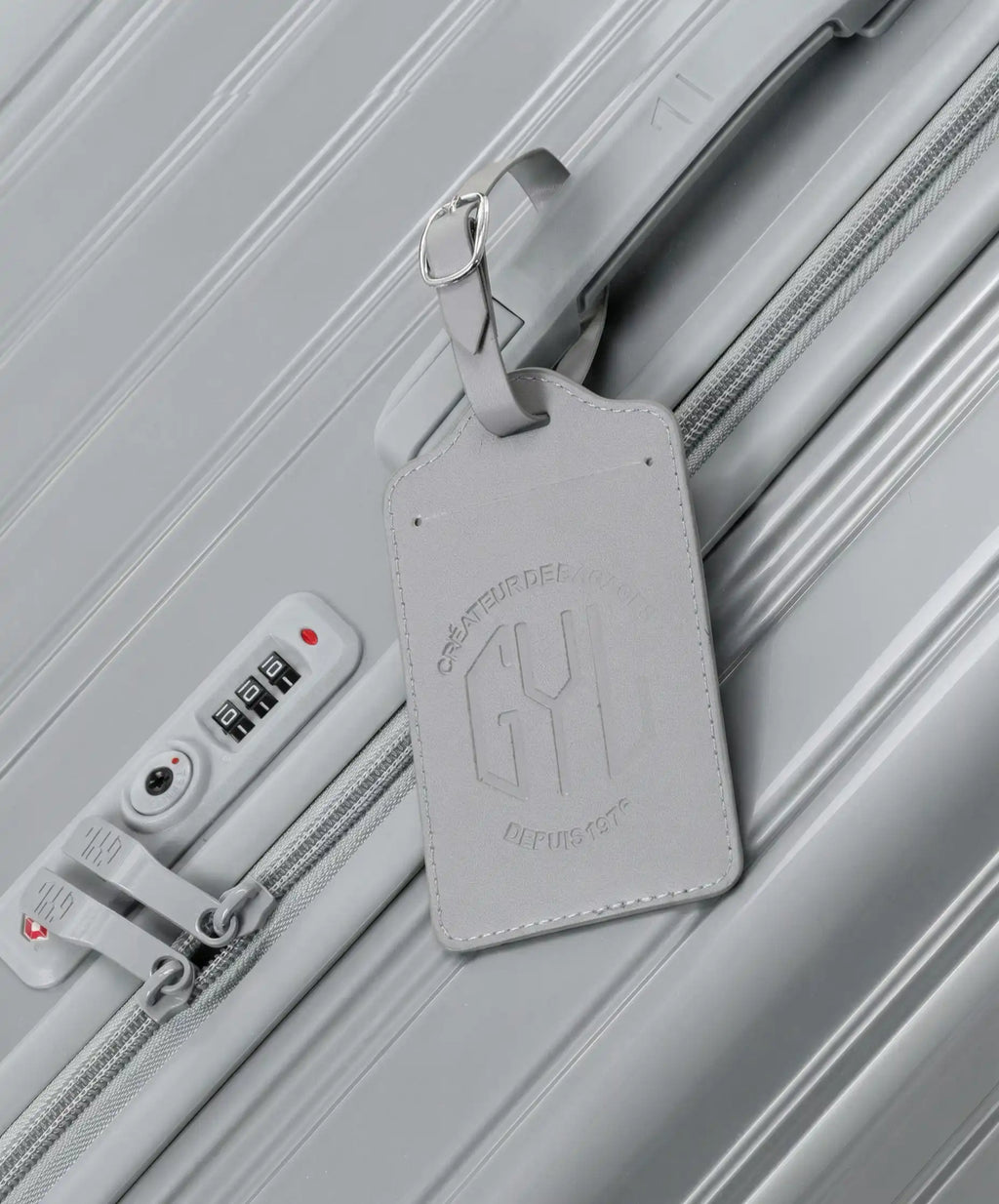 Etiquette a bagages GYL argent accrochee sur valise Intemporelle argent