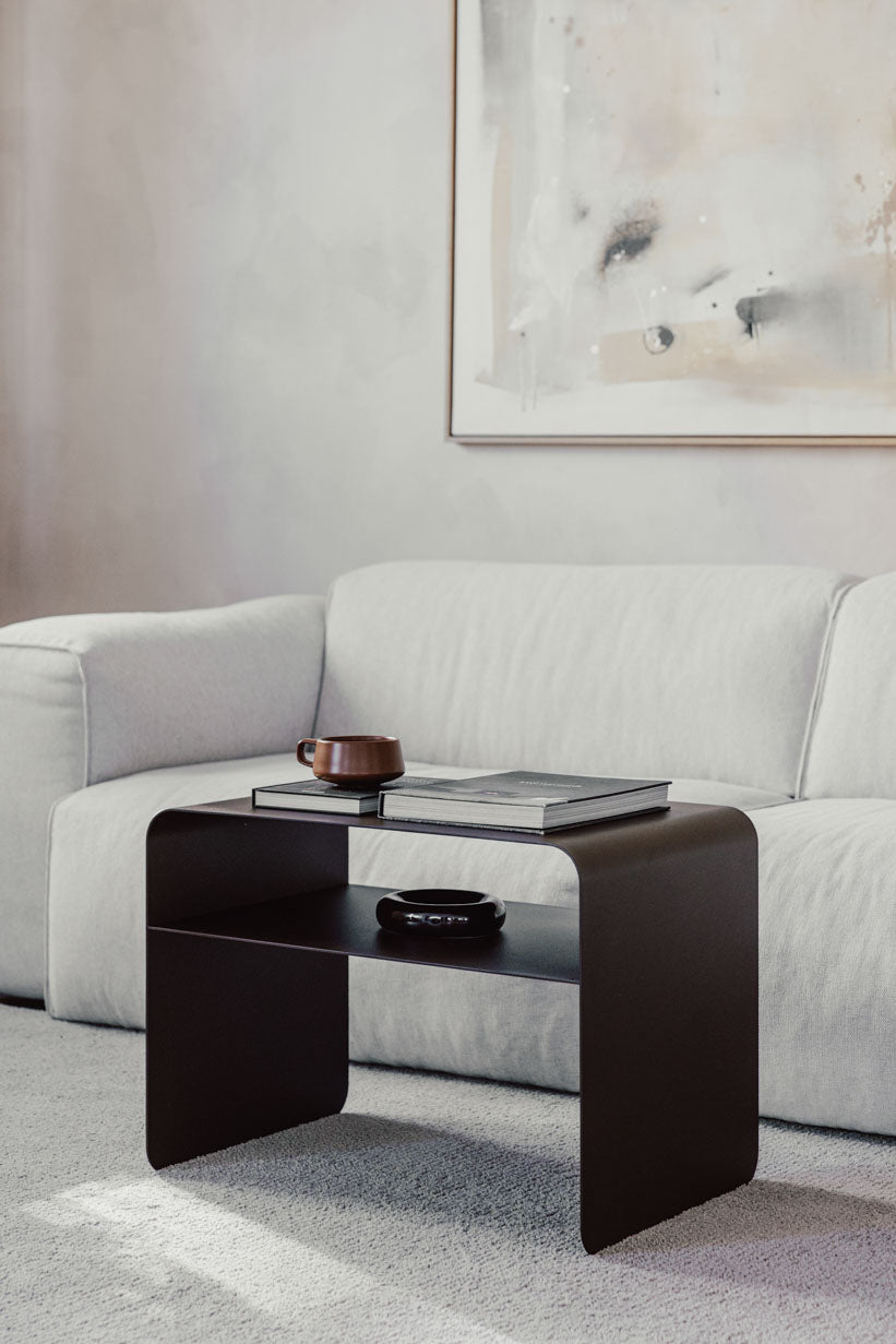 Beistelltisch COSMO aus pulverbeschichtetem Metall vor hellgrauem Sofa, modern und funktional.