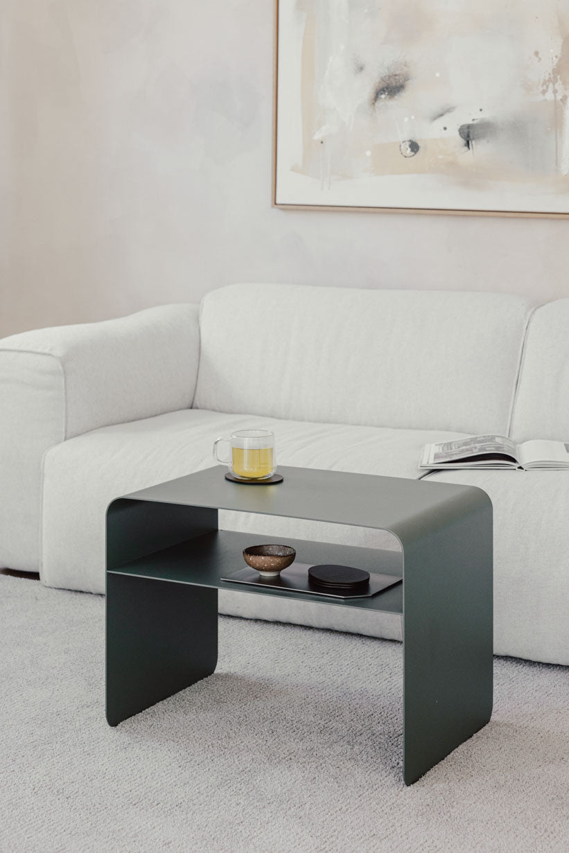 Beistelltisch COSMO aus pulverbeschichtetem Metall, modern und minimalistisch, neben einem Sofa platziert.