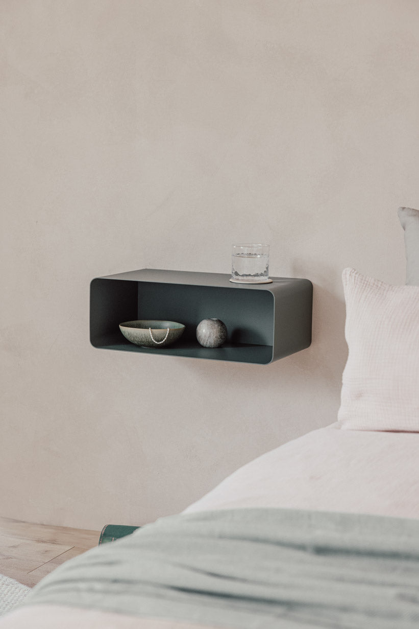 Hängender Nachttisch NELIO in modernem Design an einer Wand mit Dekorationselementen.