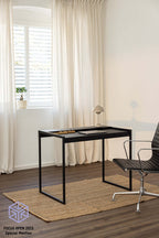 Schreibtisch DONNA in modernem Raum mit Stuhl und Teppich, minimalistisches Design in Schwarz.